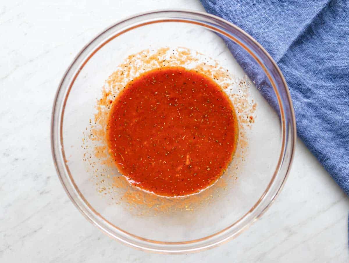 Step one mixing olive oil tomato paste broth and spices in large bowl.