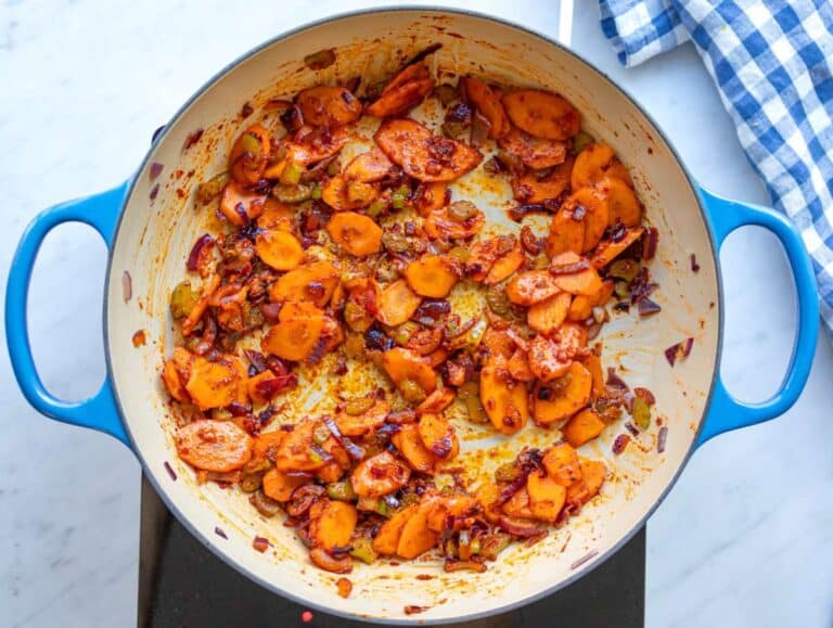 Step one onion carrot and celery cooking with tomato paste and spices to build flavor base.