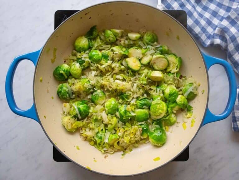 Step one sautéing leeks green onions and Brussels sprouts in olive oil.
