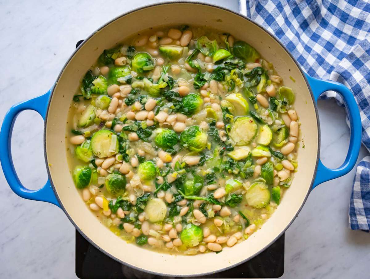 Step three simmering beans and broth into a comforting Mediterranean skillet.