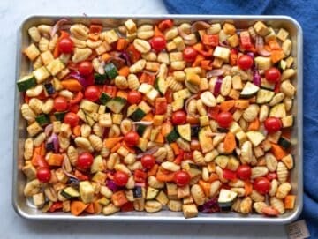 Step three spreading vegetables and gnocchi mixture evenly on sheet pan before roasting.