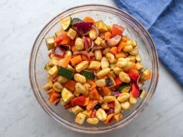 Step two adding chopped vegetables and uncooked gnocchi to bowl for tossing.