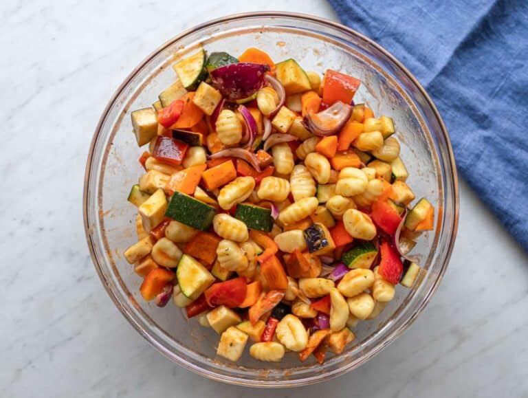 Step two adding chopped vegetables and uncooked gnocchi to bowl for tossing.
