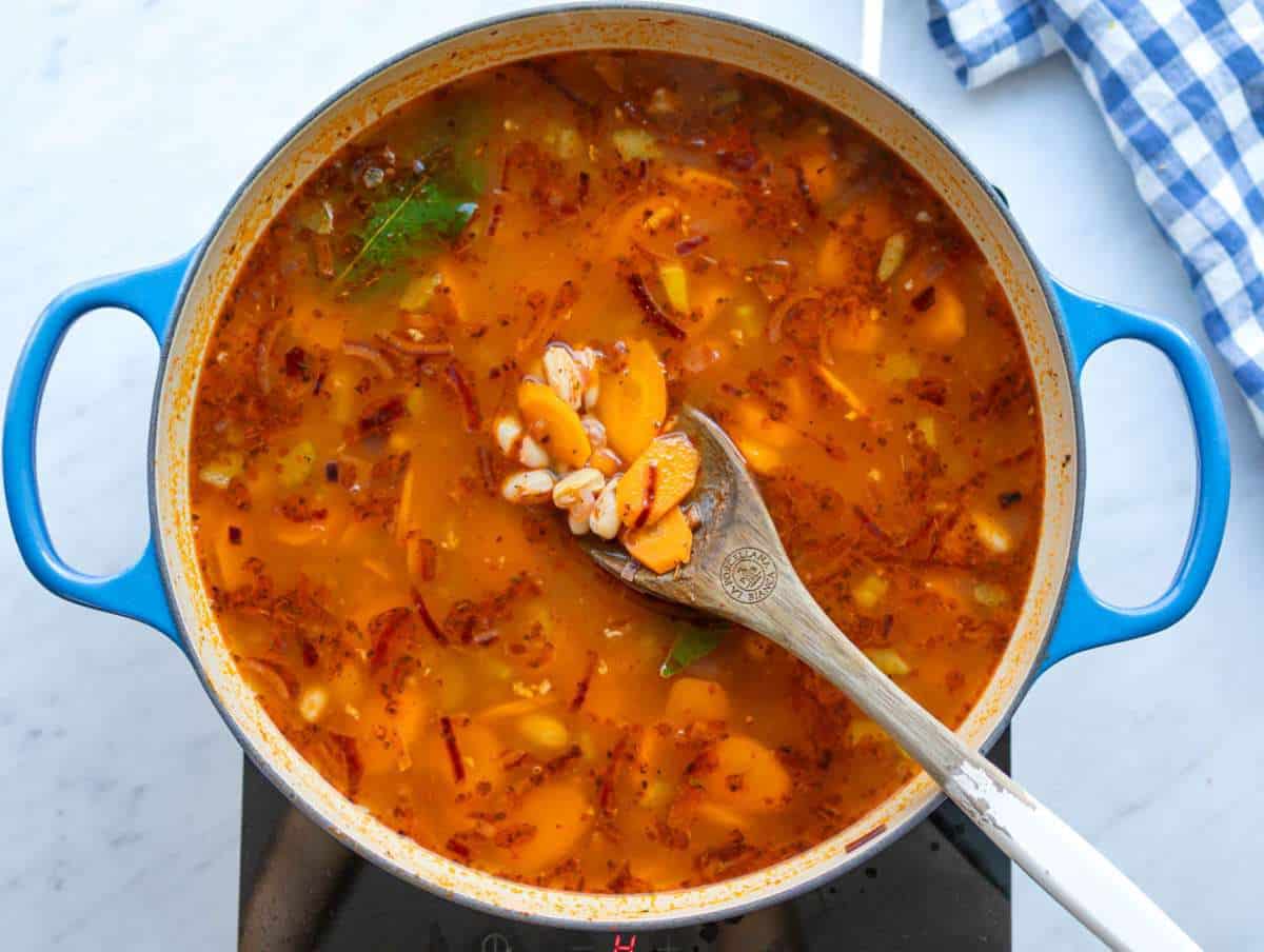 Step two simmering beans and broth to develop rich Mediterranean taste.