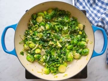 Step two wilting fresh spinach into the vegetable mixture.