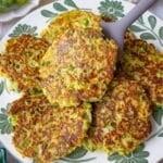 Tasty broccoli fritters on a white plate with a squeeze of lemon for healthy dinner.