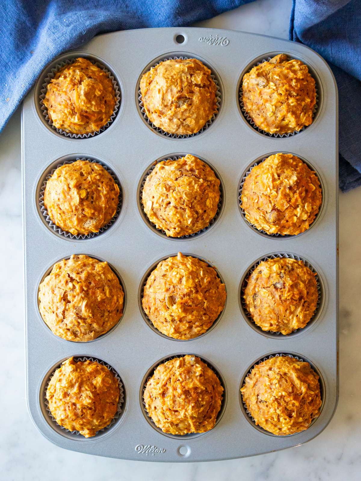 Top down view of finished oil free carrot cake muffins with golden dome tops.