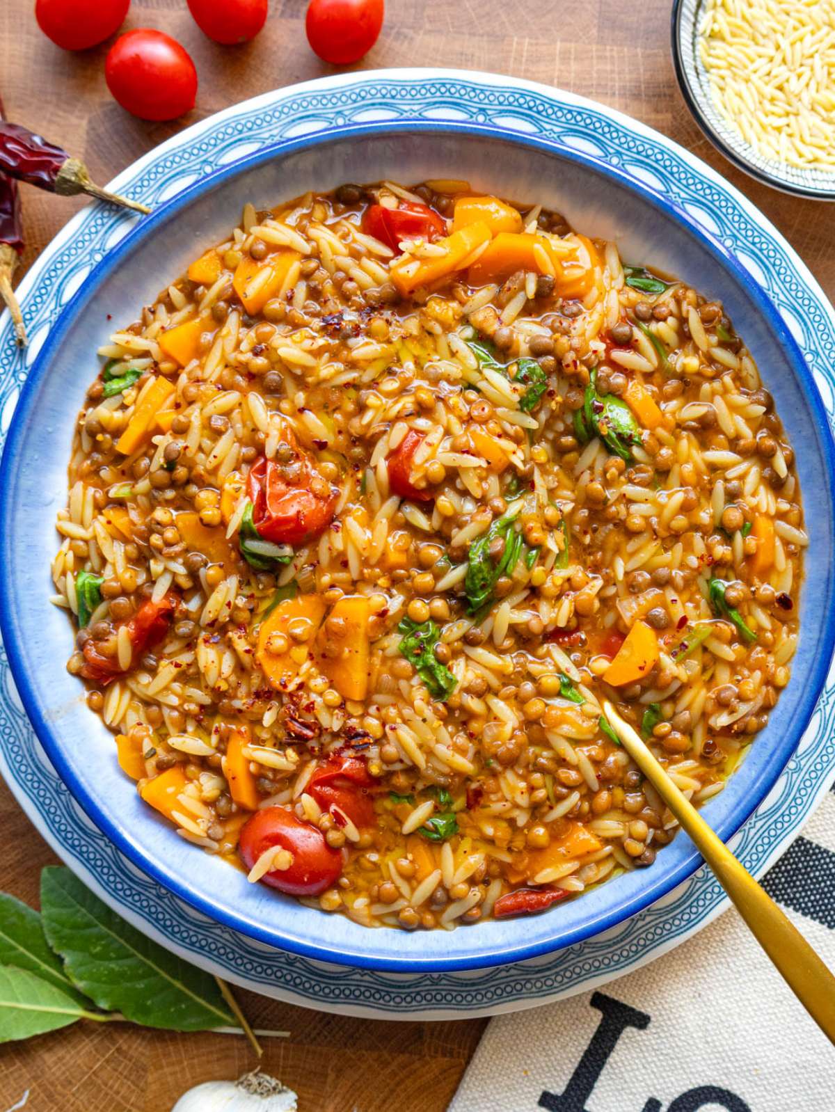 Top view of one pot lentil and orzo recipe with parsley and lemon garnish.