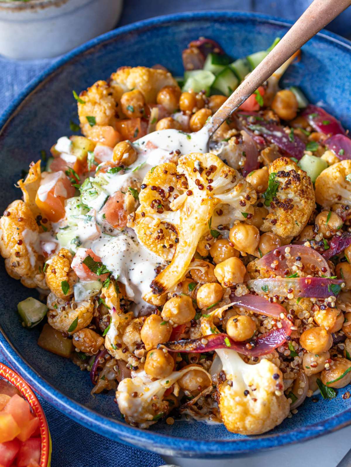 Cauliflower shawarma bowl with colorful vegetables herbs and creamy lemon sauce.