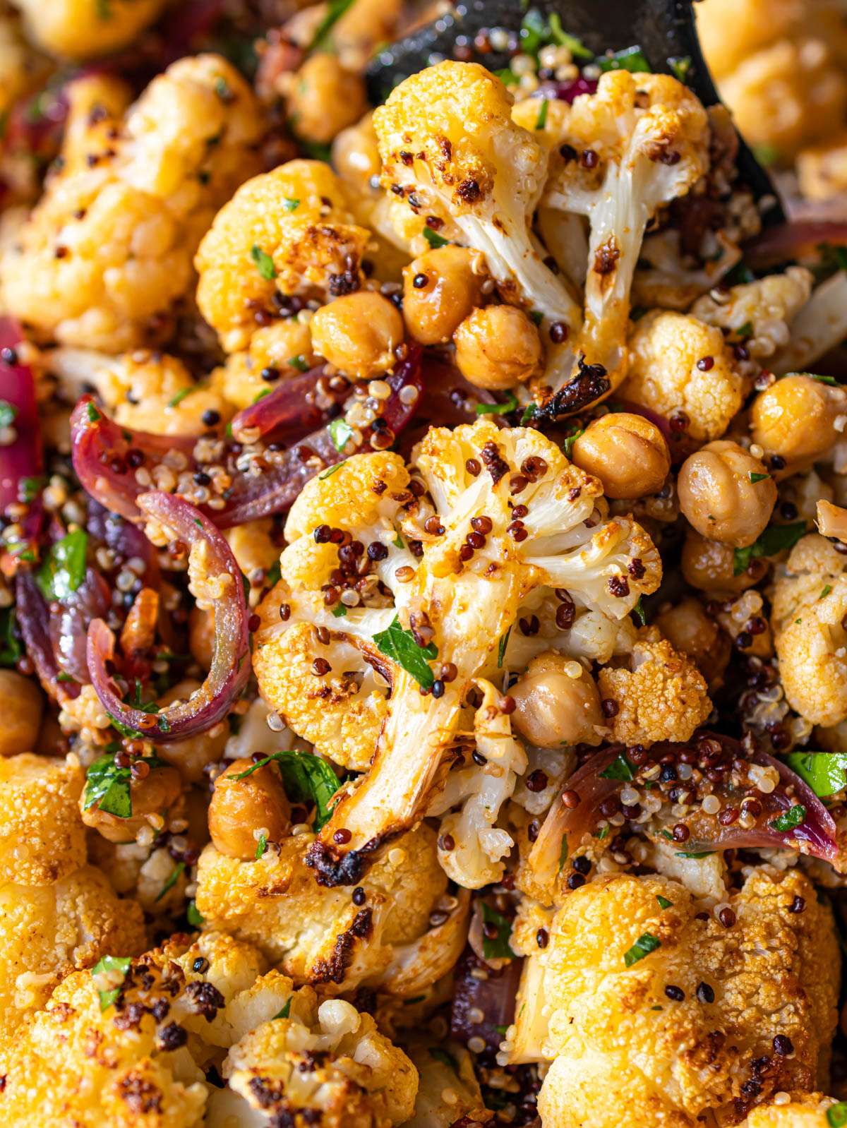 Close up cauliflower shawarma bowl cooked on a sheet pan with roasted veggies and quinoa.