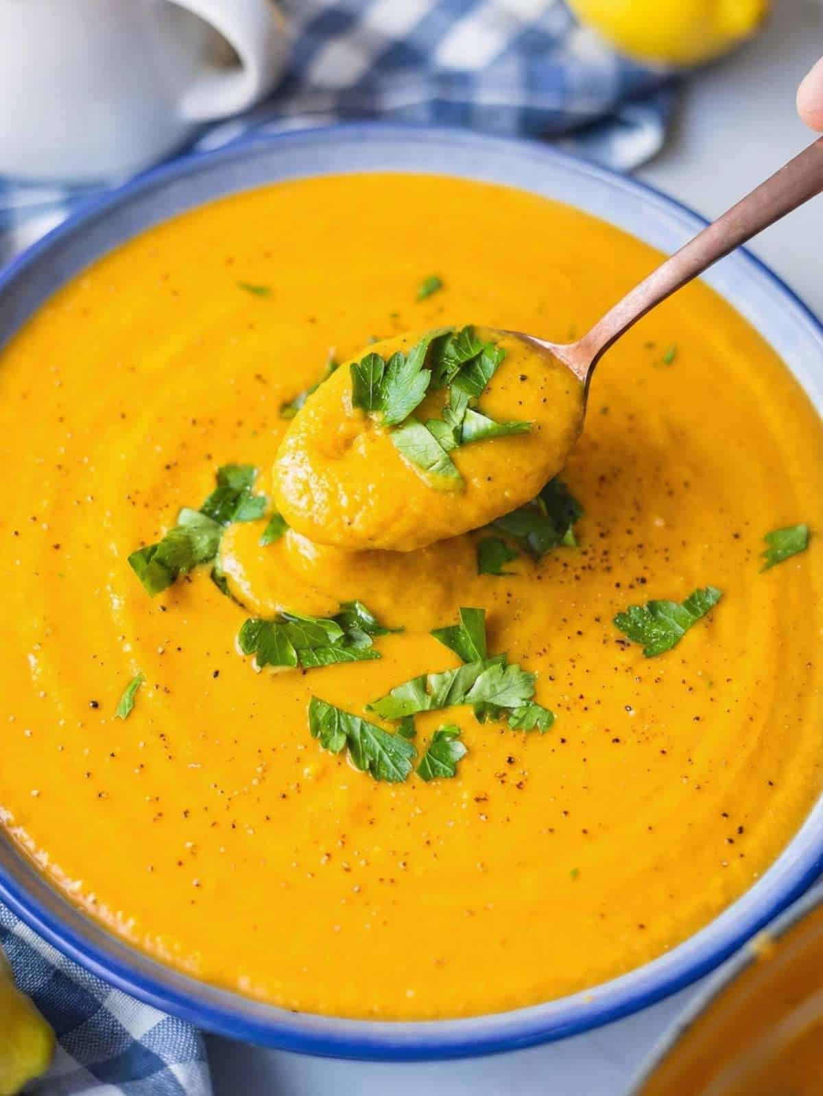 Close up of creamy sweet potato chickpea soup showing smooth texture and chickpeas blended into the soup.