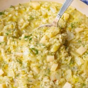 Creamy cabbage rice with melting cheese being served from a large dutch oven.