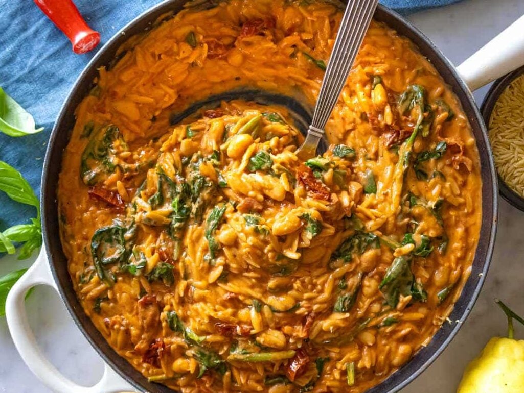Creamy marry me orzo in a skillet with a spoon.