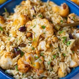Feature image showing vibrant roasted cauliflower orzo with olives feta and parsley.