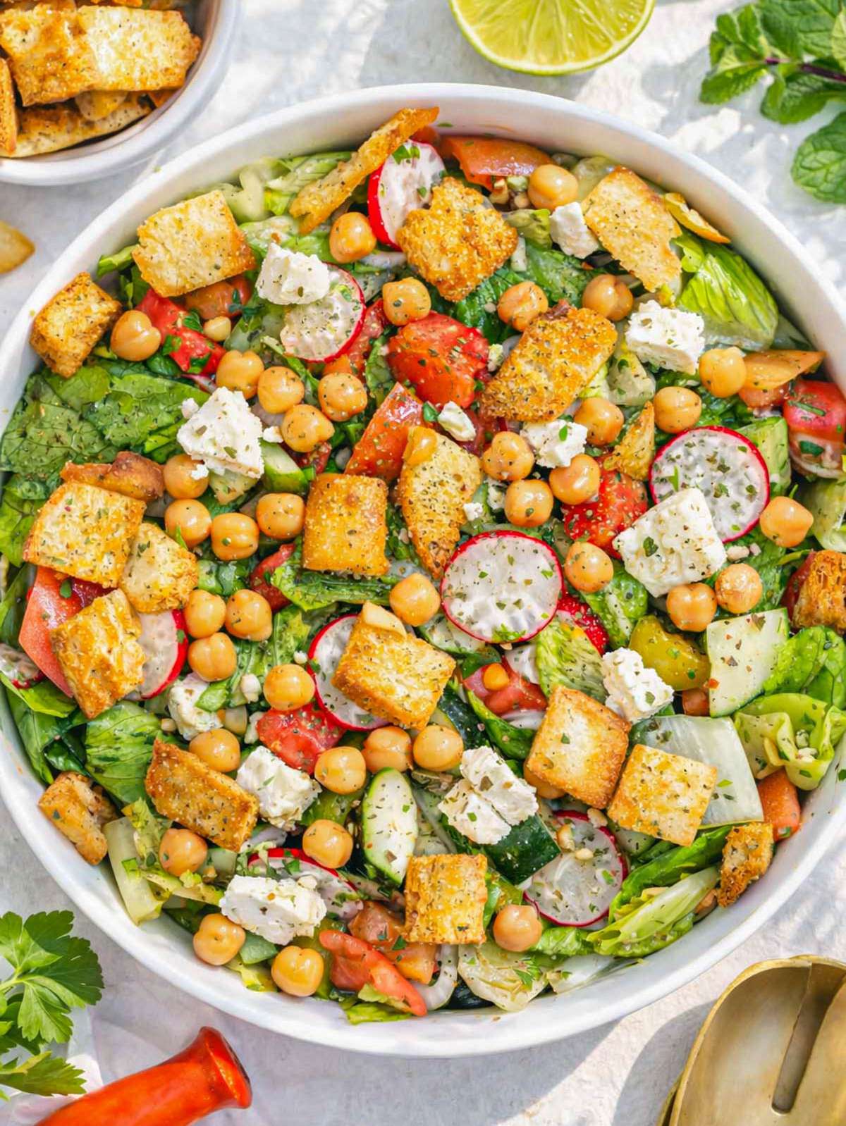 Finished pita salad served in bowl with fresh vegetables chickpeas and creamy feta.