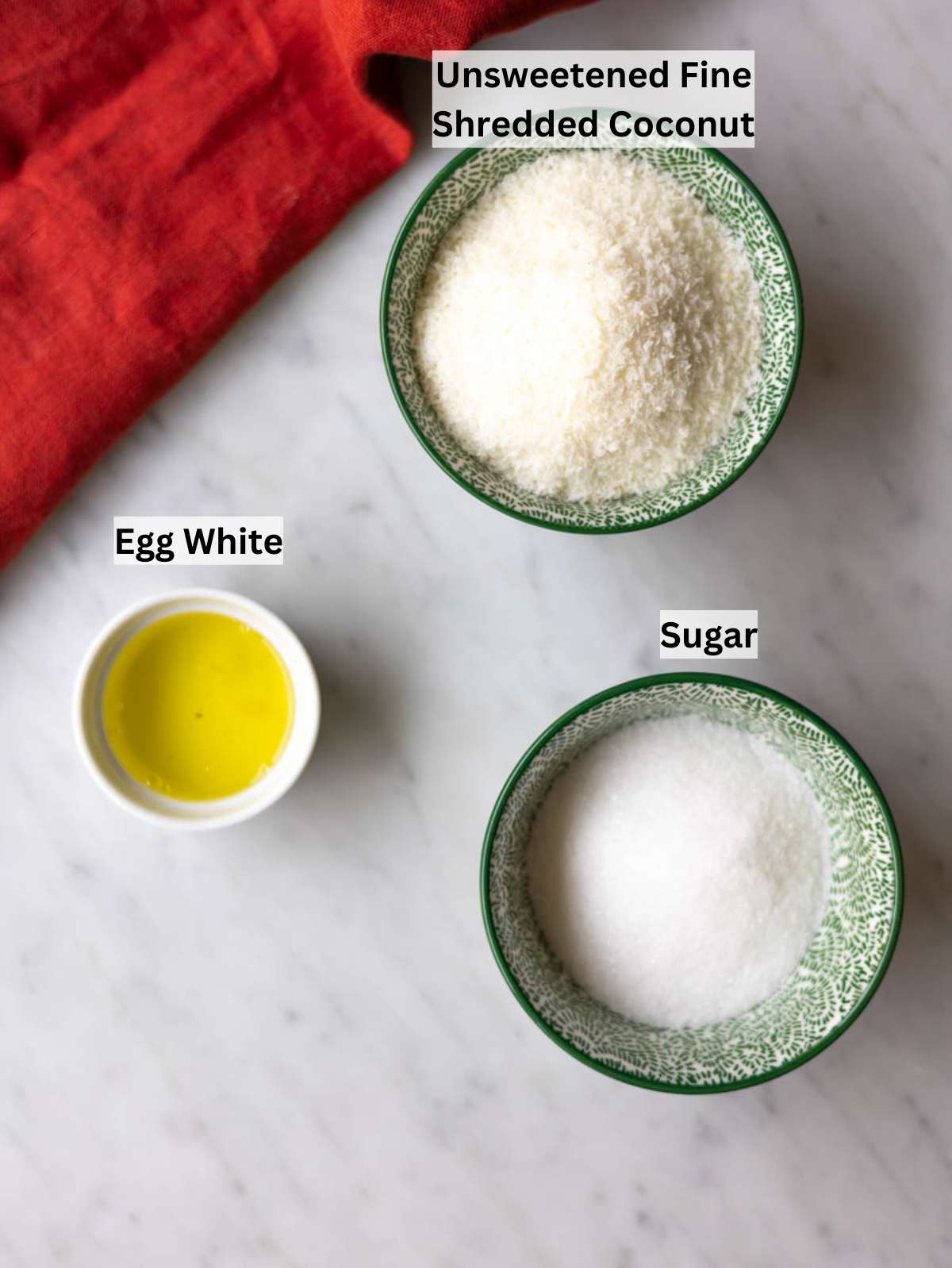 Ingredients for coconut macaroons coconut sugar and egg white on counter.