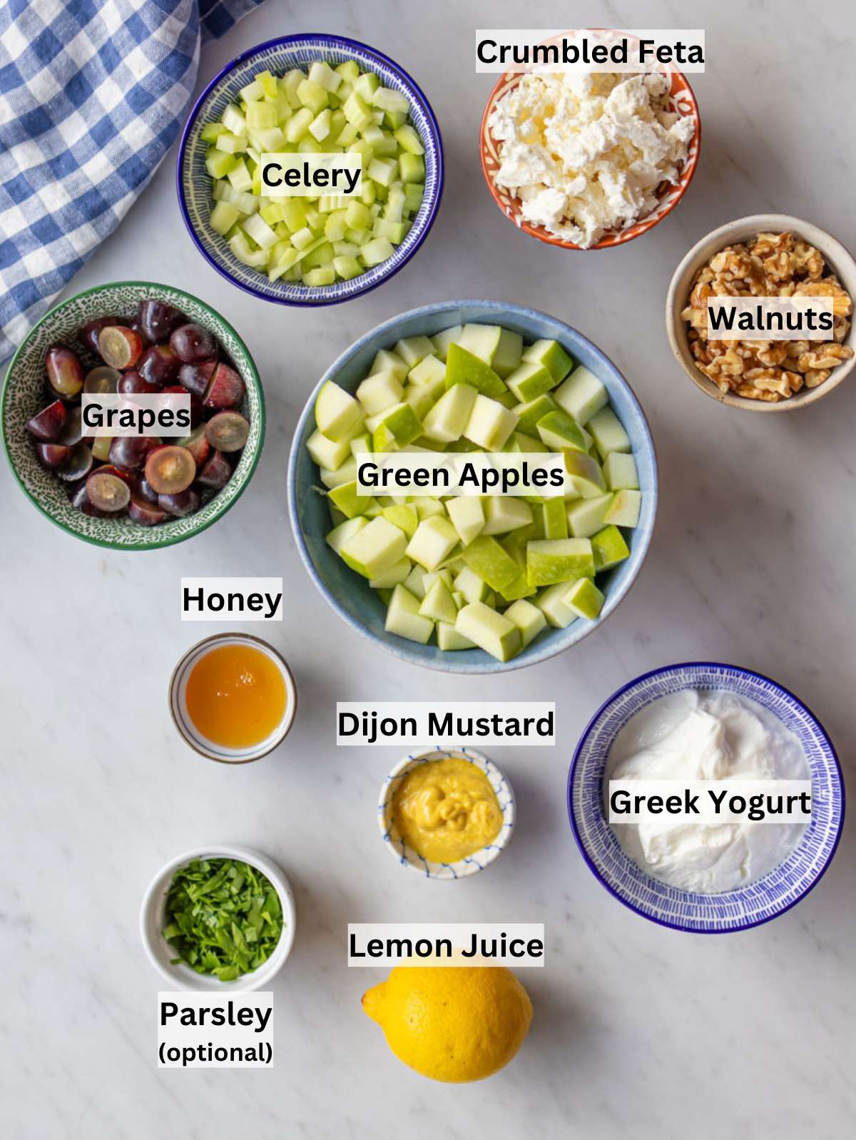Ingredients for healthy Waldorf salad arranged on a board with apples celery and grapes.