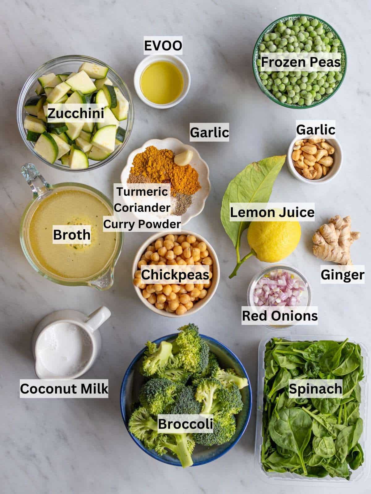 Ingredients for lemon vegetable curry arranged on a white marble surface.