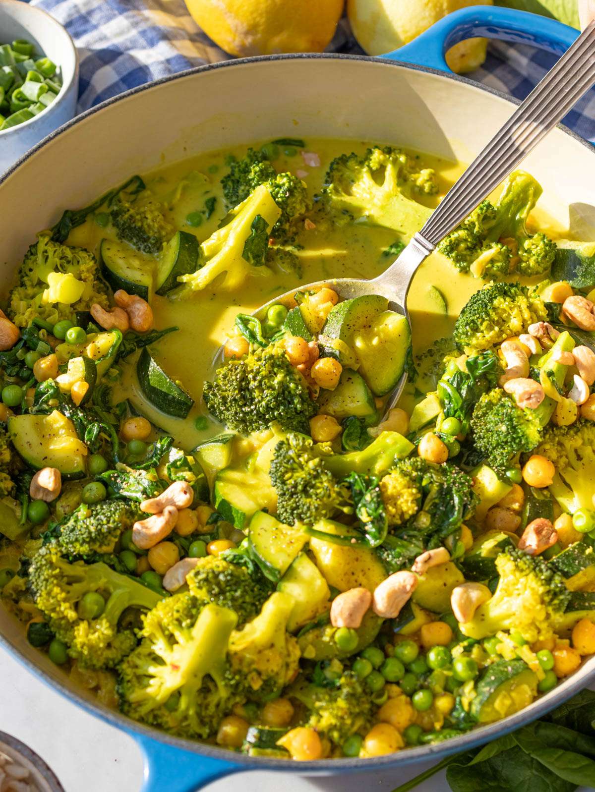 Lemon vegetable curry in a large skillet with creamy sauce and bright green vegetables.