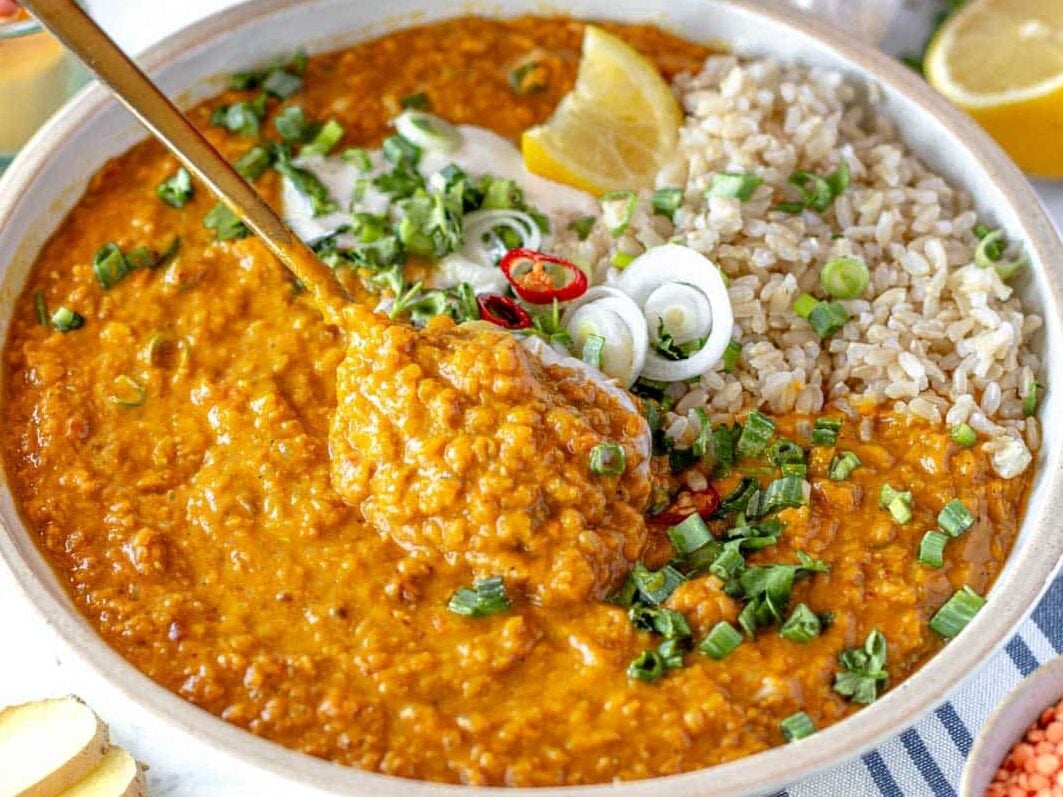 a spoonful of red lentil curry with rice and lemon