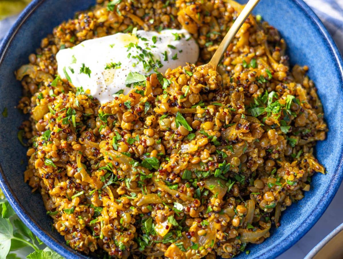 Mediterranean Lentils and quinoa skillet styled in a bowl with Greek yogurt and parsley.