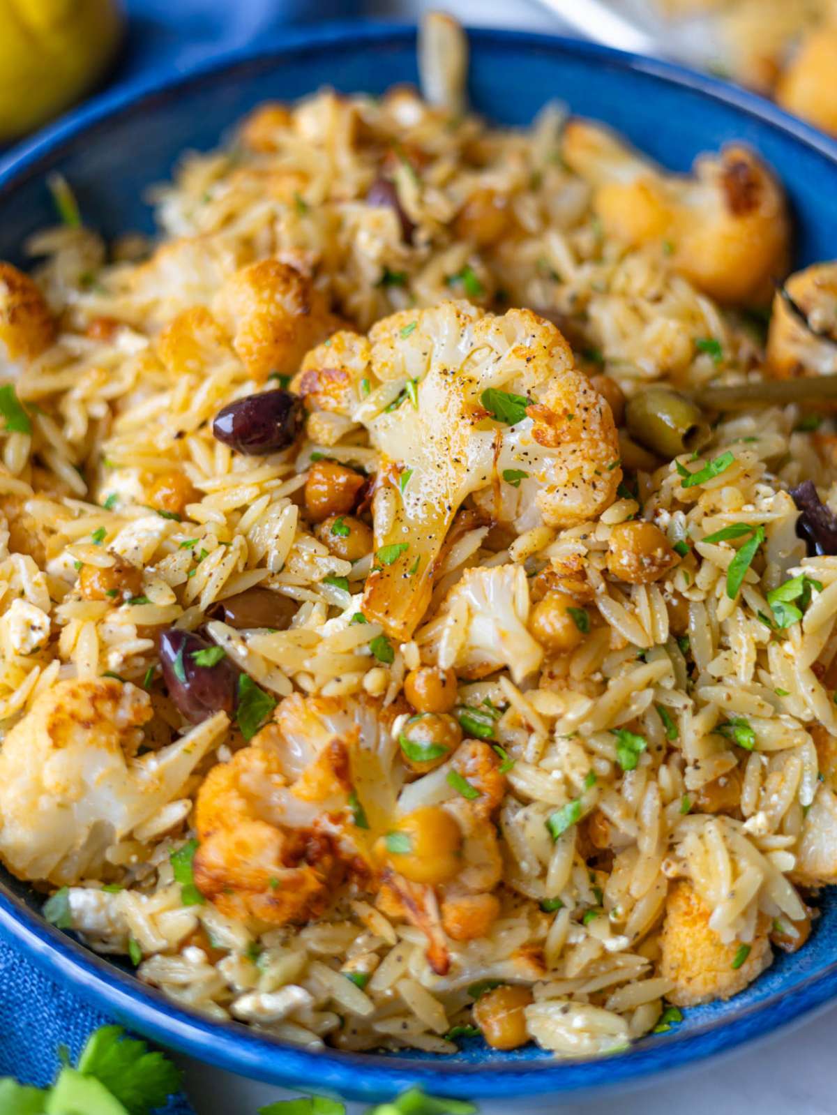 Mediterranean roasted cauliflower orzo bowl with chickpeas and feta.