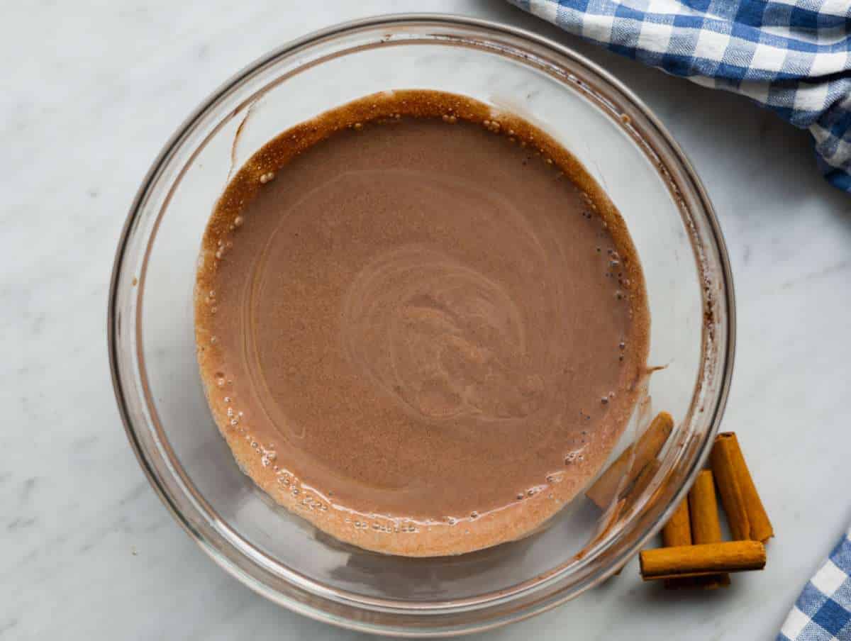 Mixing Greek yogurt milk cocoa and honey until smooth base for chocolate chia pudding.