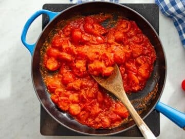 Step 1 Blistering cherry tomatoes in skillet with garlic and oregano for pizza beans.