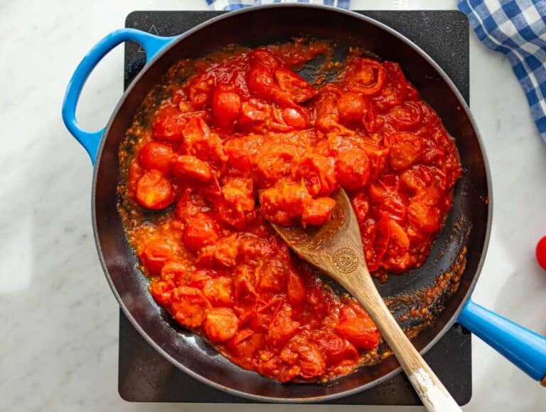 Step 1 Blistering cherry tomatoes in skillet with garlic and oregano for pizza beans.