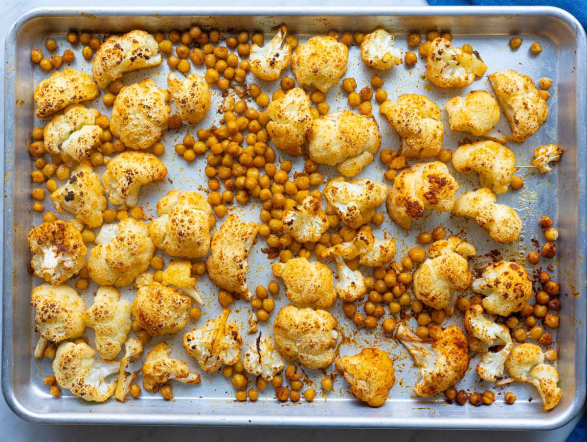 Step 1 Roasted cauliflower and chickpeas on sheet pan ready for Mediterranean orzo dinner.