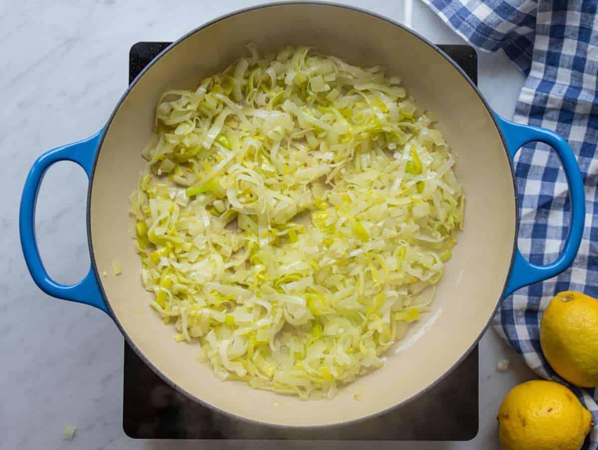 Step 1 Sauteฬing chopped leeks and onions in olive oil for the savory flavor base.
