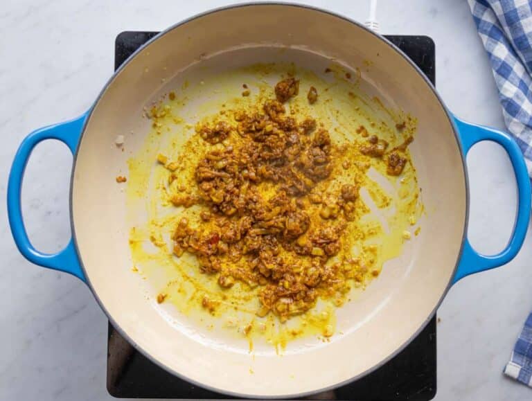 Step 1 Sautéing onions garlic ginger and spices for the curry base.