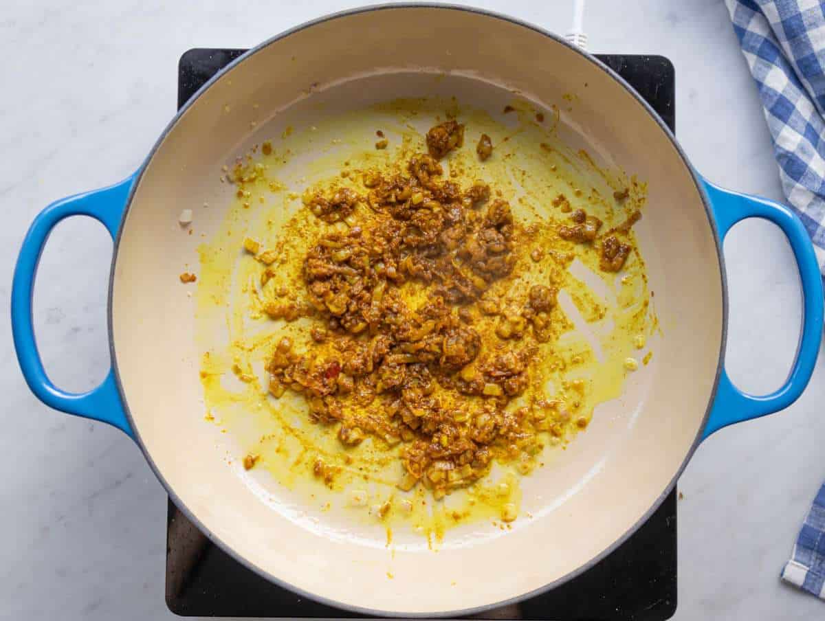 Step 1 Sautéing onions garlic ginger and spices for the curry base.