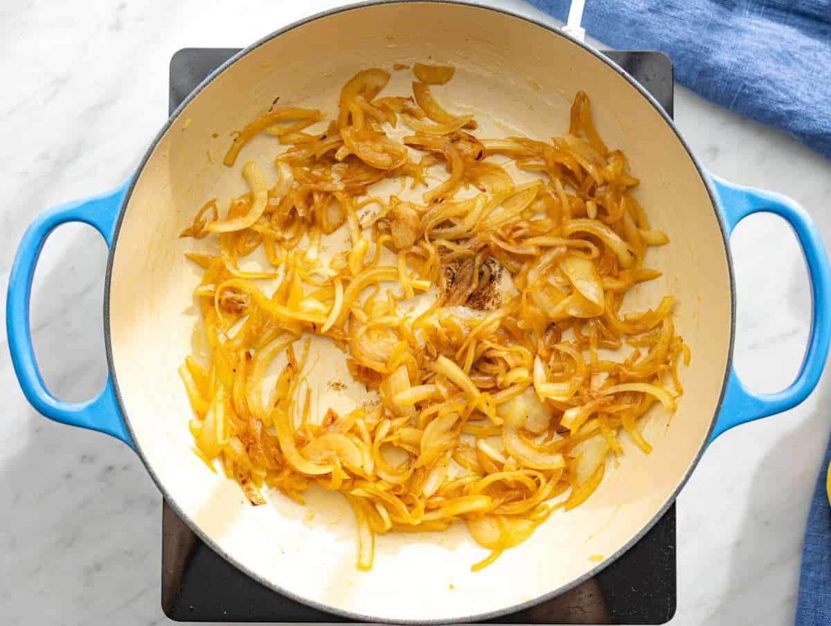 Step 1 Sliced onions caramelizing in skillet with olive oil and honey.