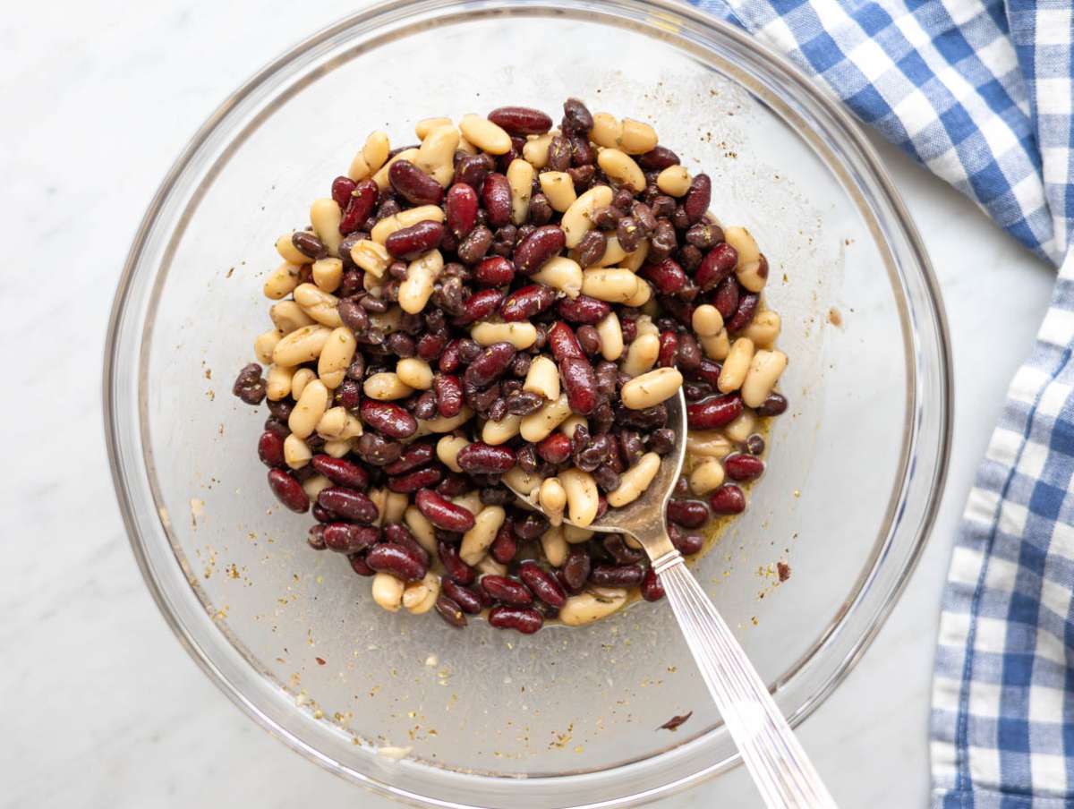 Step 1 Whisking dressing and mixing it with beans for quick bean marinade in large bowl.