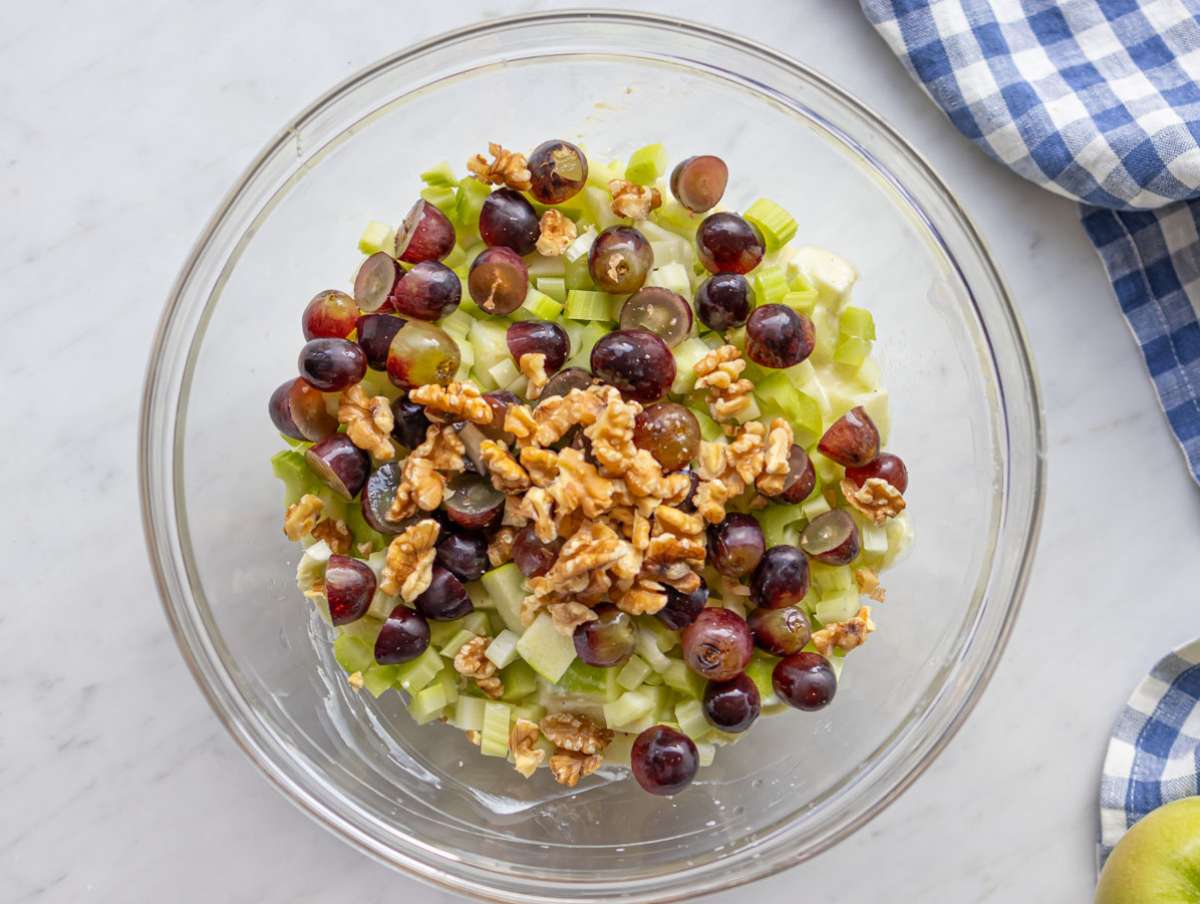 Step 2 Chopped apples celery and grapes tossed with dressing for healthy Waldorf salad.