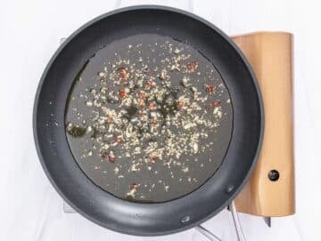 Step 2 Garlic and chili gently warming in olive oil for traditional aglio e olio sauce.