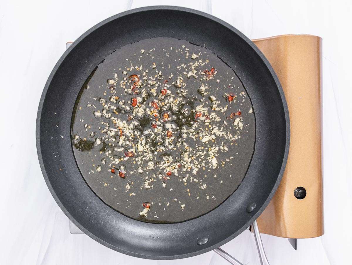 Step 2 Garlic and chili gently warming in olive oil for traditional aglio e olio sauce.