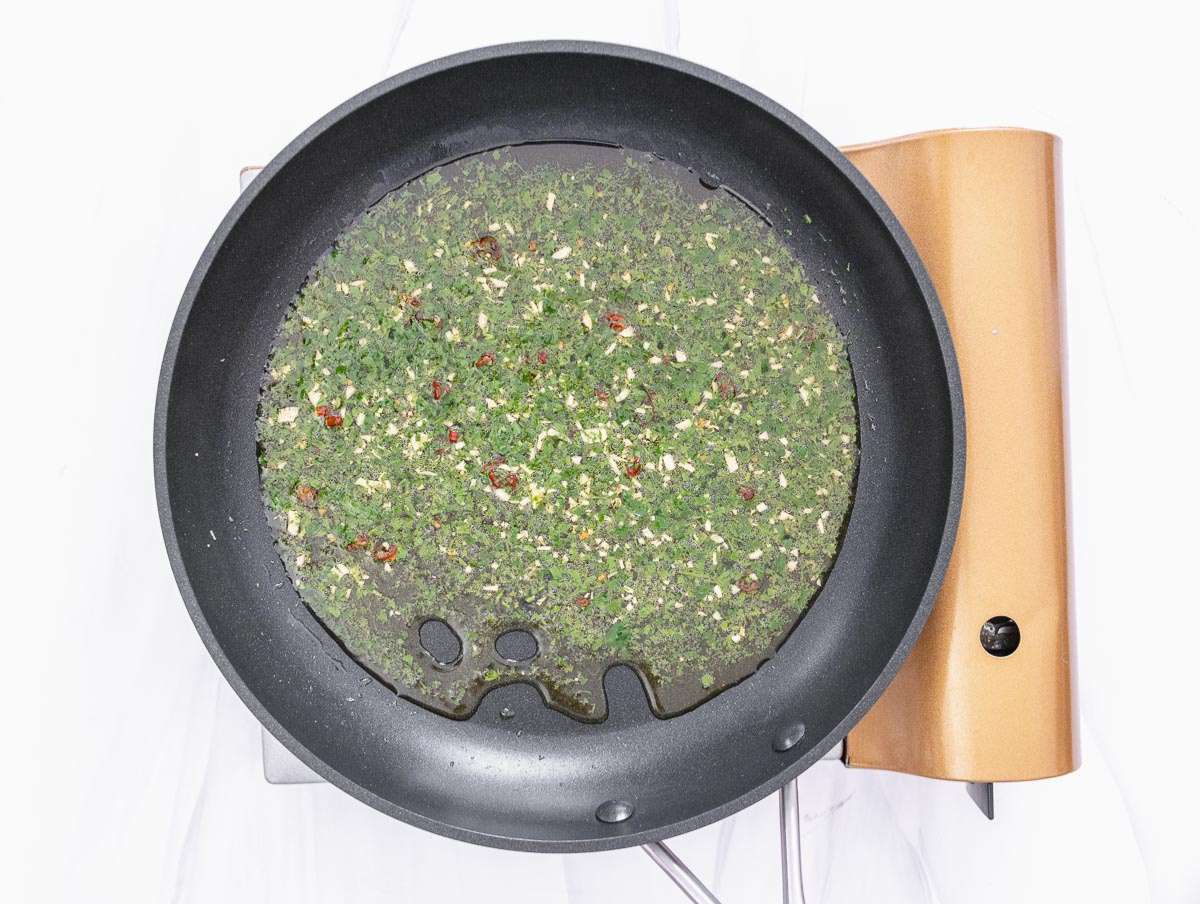 Step 3 Adding parsley to garlic oil to finish classic Italian pasta flavor.