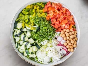 Step 3 Chopped vegetables and chickpeas added to bowl for pita salad base.