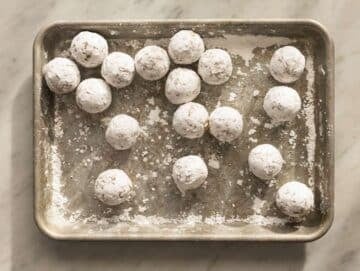 Step 3 Shaping Italian almond cookie dough into small balls rolled in powdered sugar.