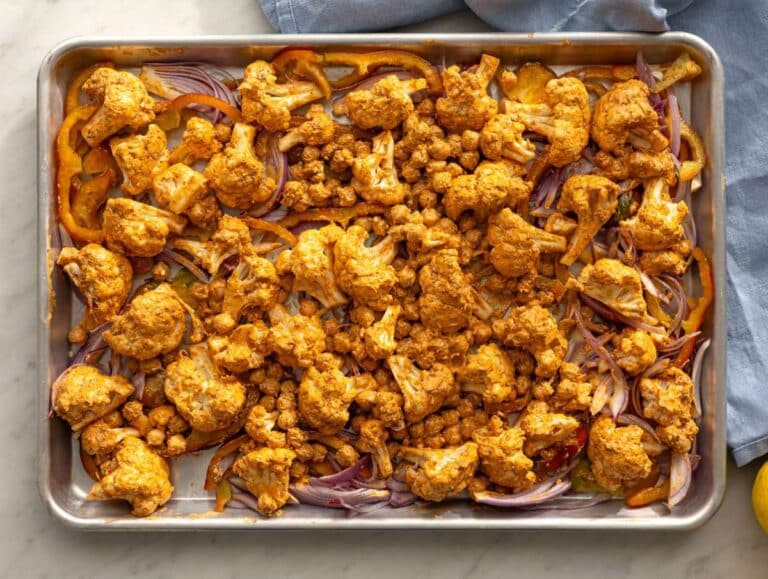 Step 3 Sheet pan with onions peppers and marinated cauliflower ready for oven.