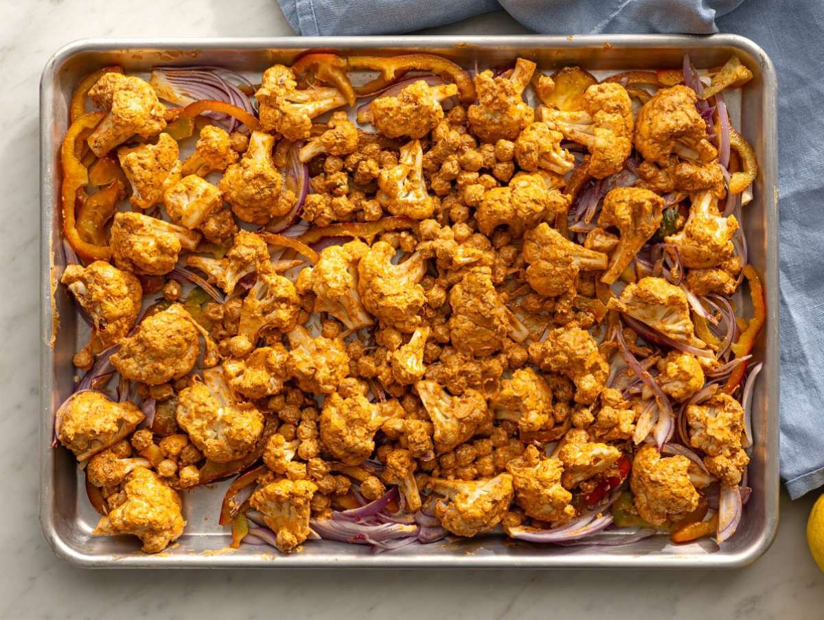 Step 3 Sheet pan with onions peppers and marinated cauliflower ready for oven.