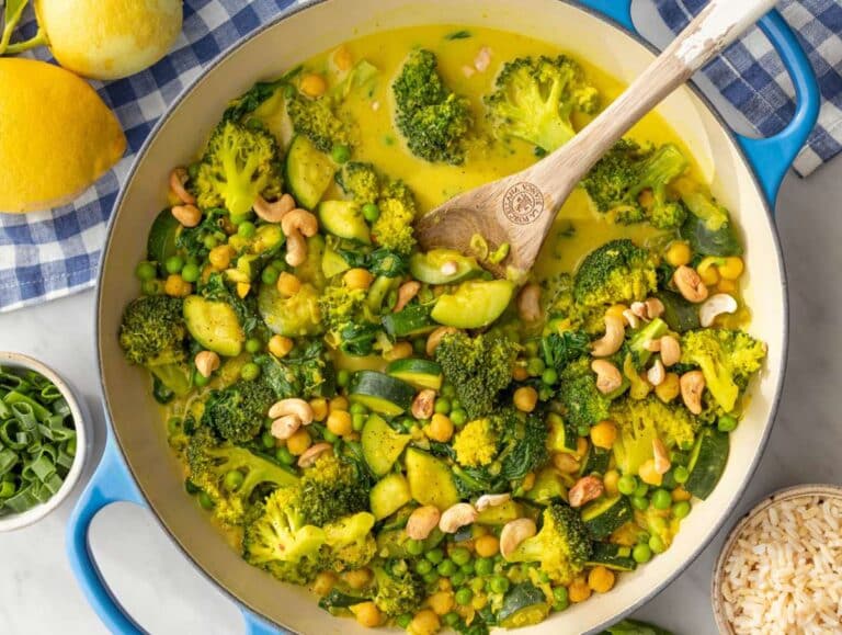 Step 3 Stirring peas and spinach into creamy simmered vegetable curry.