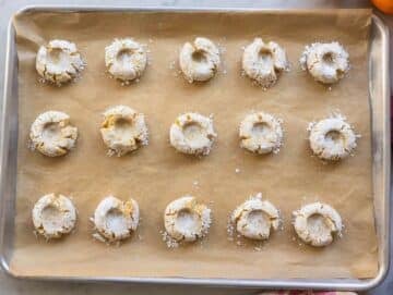 Step 4 Pressing almond cookie dough balls with thumb to create classic crackled edges and baking for 12 minutes.