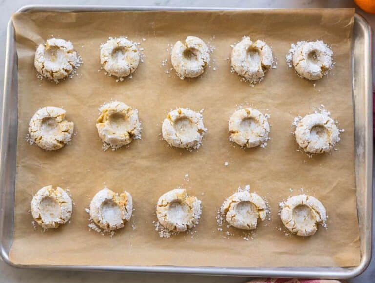 Step 4 Pressing almond cookie dough balls with thumb to create classic crackled edges and baking for 12 minutes.