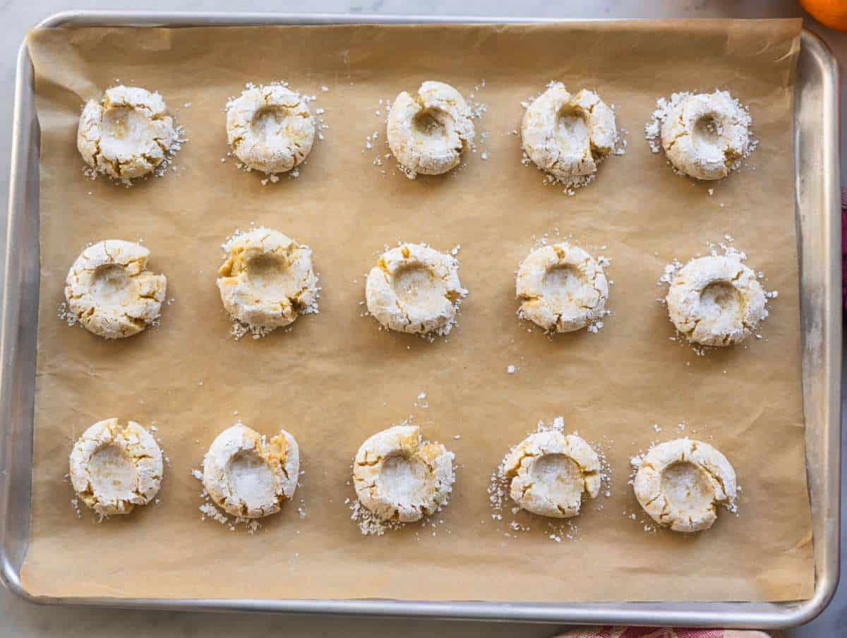 Step 4 Pressing almond cookie dough balls with thumb to create classic crackled edges and baking for 12 minutes.