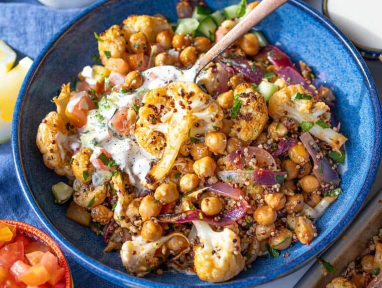Step 4 Quinoa mixed with the roasted cauliflower and chickpeas and served in a bowl with a lemony yogurt sauce.
