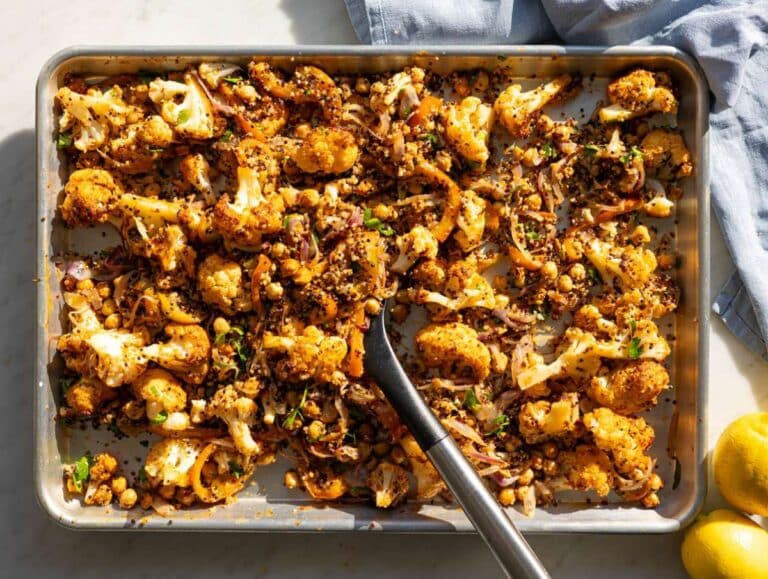 Step 4 Tossing quinoa into roasted vegetables for cauliflower grain bowl.