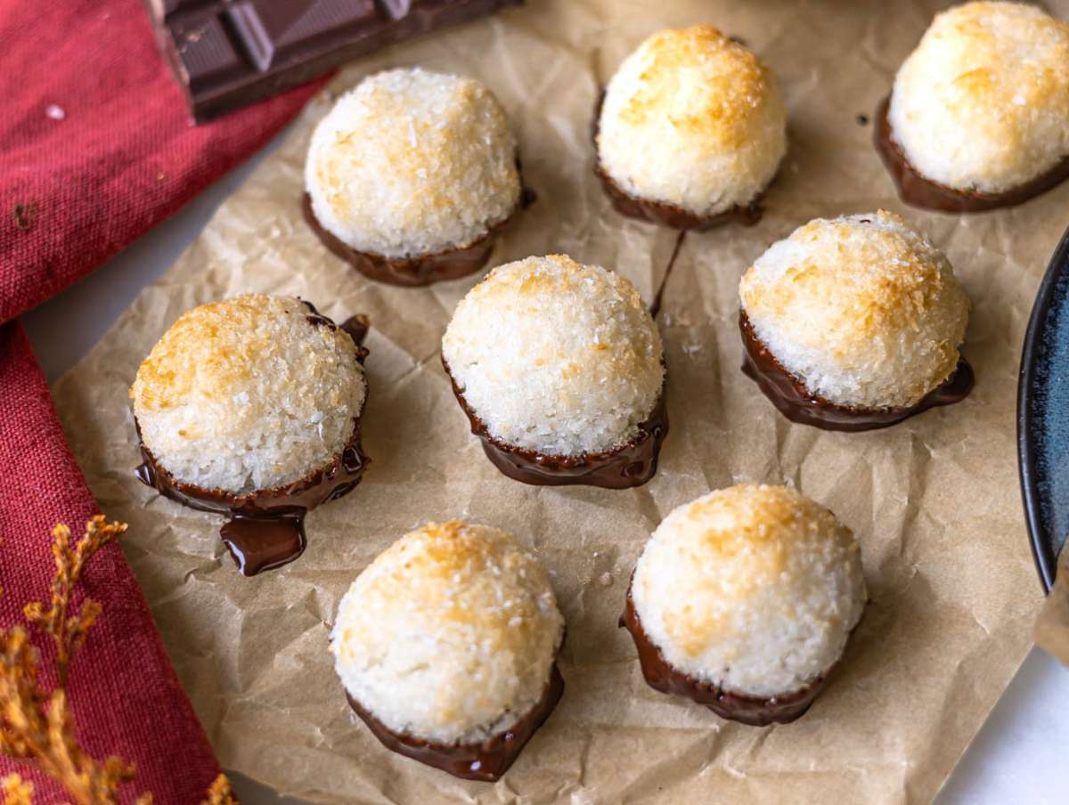 Step 5 Chocolate dipped coconut macaroons resting on parchment paper to allow glossy dark chocolate coating to set.